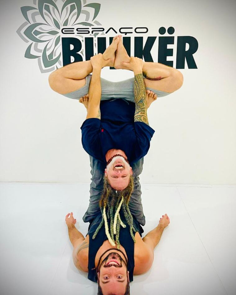Dupla praticando acroyoga no tatame